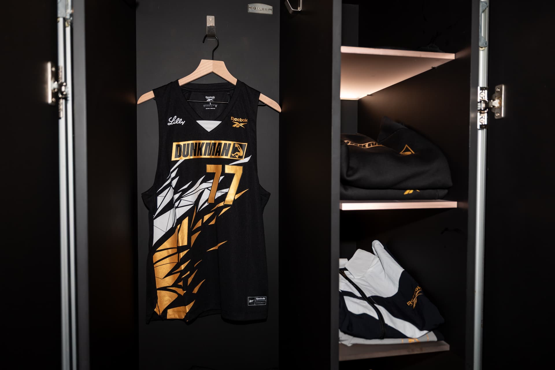 Dunkman League 77 jersey hanging in the locker beside folded kit