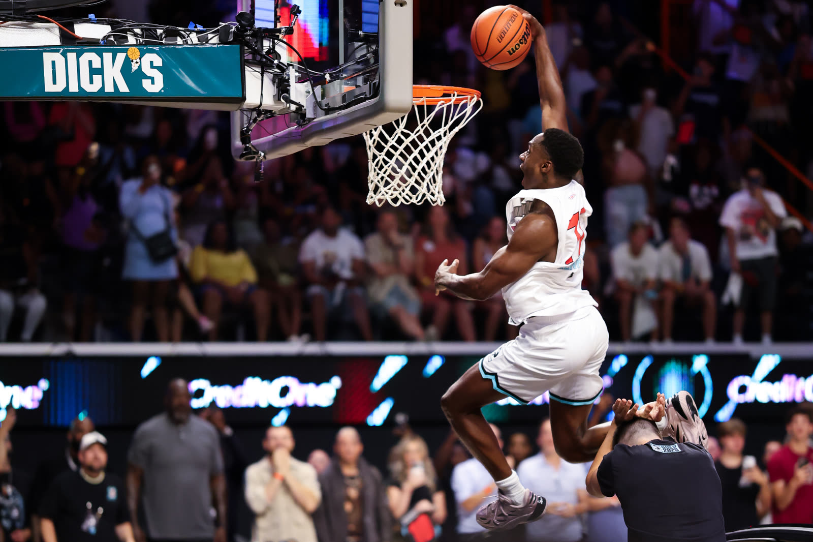 The Royal Guard finishing a one-handed dunk over a crouching man at a Dunkman League show